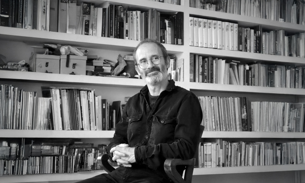 Jordi Solé a una biblioteca envoltat de llibres