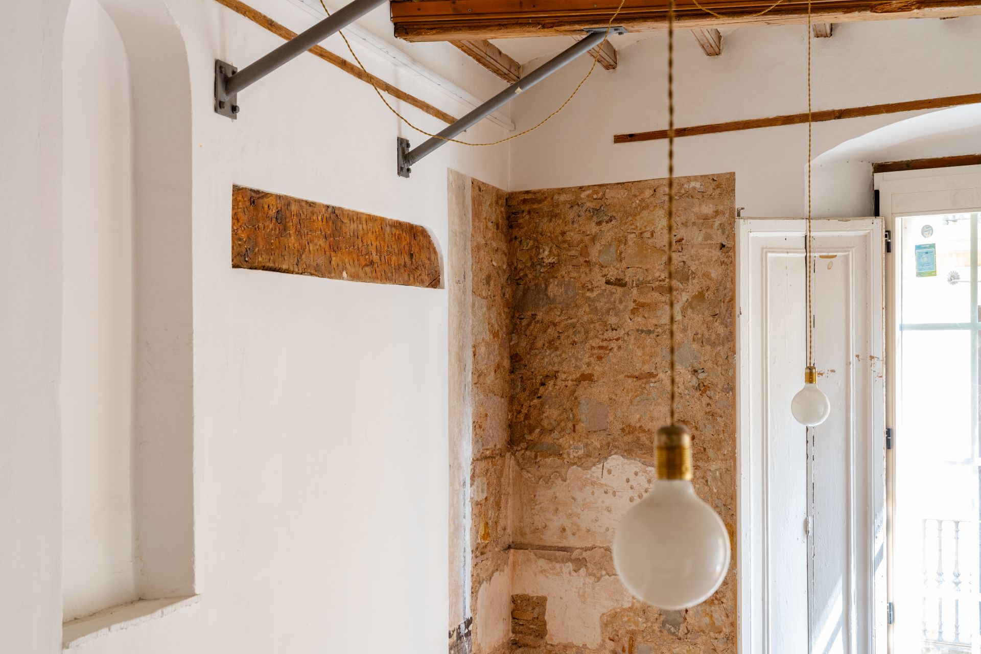 Interior d’espai rehabilitat amb parets de maó vist i llum natural