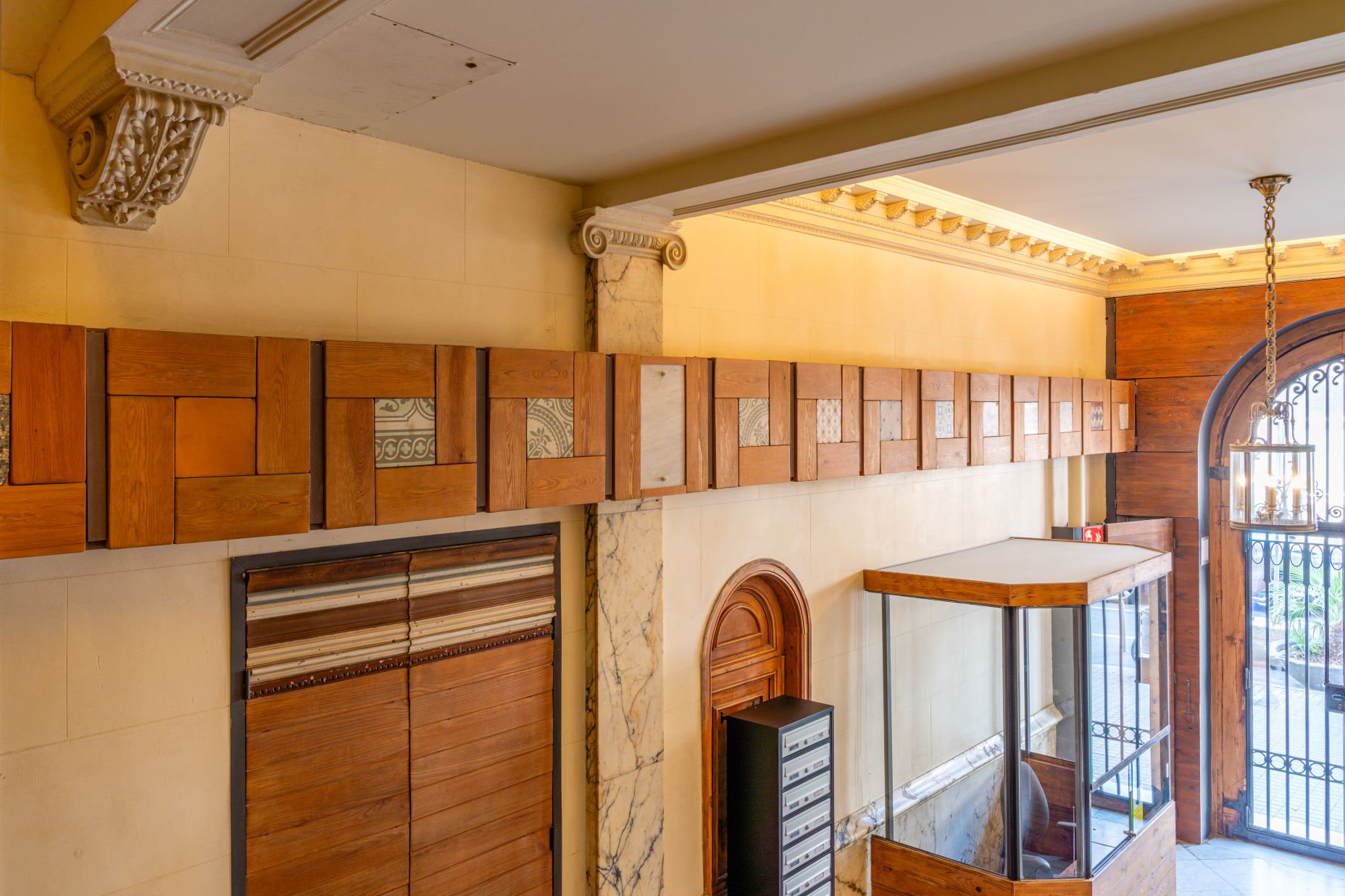 Entrada d’edifici amb elements de fusta i acabats interiors en projecte